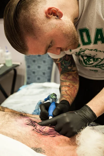 Artistas del tatuaje en el trabajo Fotos de stock