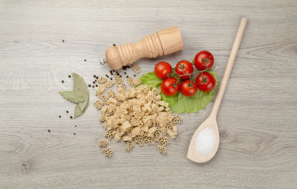 Pasta, tomate y pimienta sobre fondo de madera — Foto de Stock