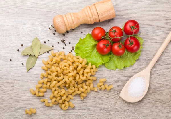 Pasta, pomodori e pepe su fondo di legno — Foto Stock