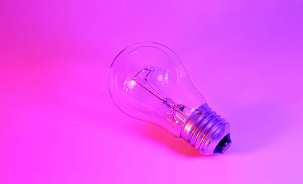 Neon lambalı ampul fotoğrafı. Fikir kavramı pembe mavi arka planda izole edilmiş, elektrikçi bakımı, zanaatkar, tamirci — Stok fotoğraf