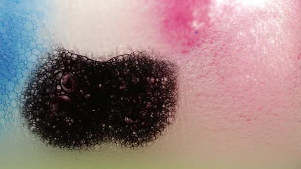 Красивые капли чернил растворяются в воде. Красочная мыльная пена с лопающимися пузырями фона. Абстрактная структура, краска заполняет массу мелких пузырьков, образующихся в жидкости. — стоковое видео