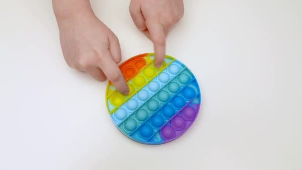 Popit antistress leksak för barn underhållning på en gul bakgrund spelar ett barn ovanifrån i färgad fijit enkel dimple popit silikon fidget, trendig sensorisk färg push — Stockvideo