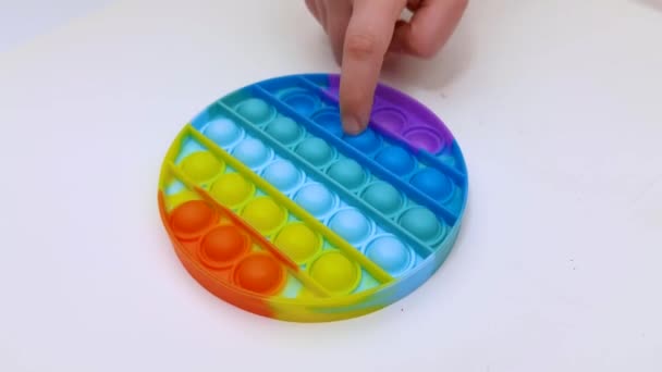 Popit jouet antistress pour le divertissement des enfants sur un fond jaune jouant une vue de dessus de l'enfant en fijit coloré simple fossette popit violon en silicone, poussoir de couleur sensorielle à la mode — Video