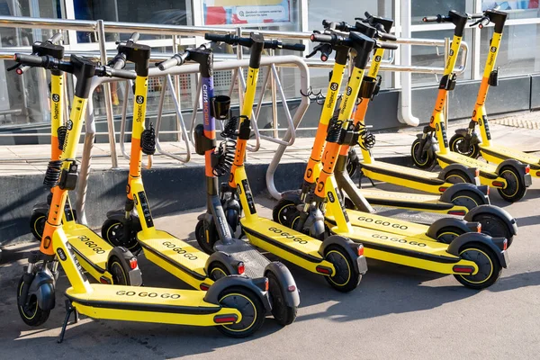 Moscow, Russia - July 21, 2021: Yandex Go yellow electric scooters for rent. urban transport. Electric Ride Sharing Scooters Lined Up on sidewalk and Ready to Rent — Stock Photo, Image