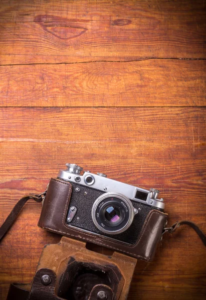 Cámara retro sobre fondo de mesa de madera, tono de color vintage — Foto de Stock