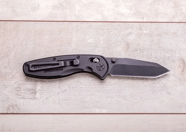 Folding knife on a wooden background — Stock Photo, Image