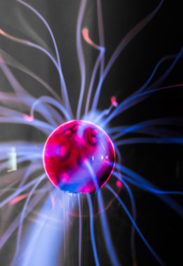Plasma ball  with magenta-blue flames isolated on a black background. clipart