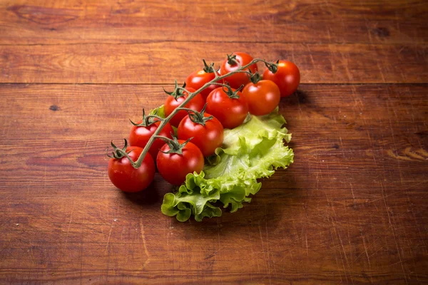 Tomates vermelhos na mesa de madeira — Fotografia de Stock