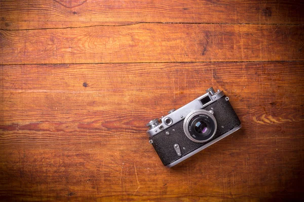 Retro-Kamera auf Holztischhintergrund, Vintage-Farbton — Stockfoto