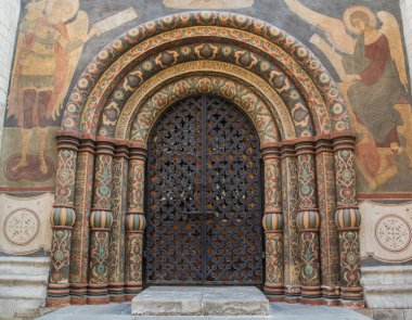 Main gate entrance into the Cathedral of the Assumption in the Kremlin. Highly decorated arches circled by paintings. clipart