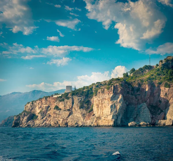 The high cliffs next to the central beach of Budva make the coastline even more scenic and romantic for boat trips, Montenegro. — Stock Photo, Image