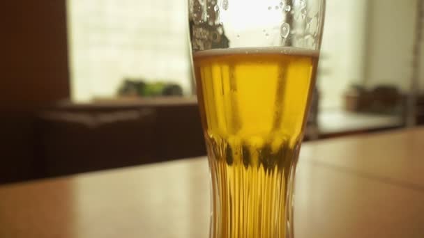 Skleněné pivo na dřevěném pozadí s kopírovacím prostorem — Stock video