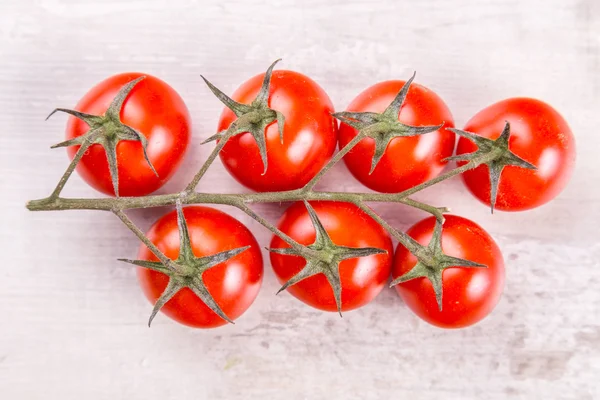 Ramo de tomate na mesa de madeira vintage — Fotografia de Stock