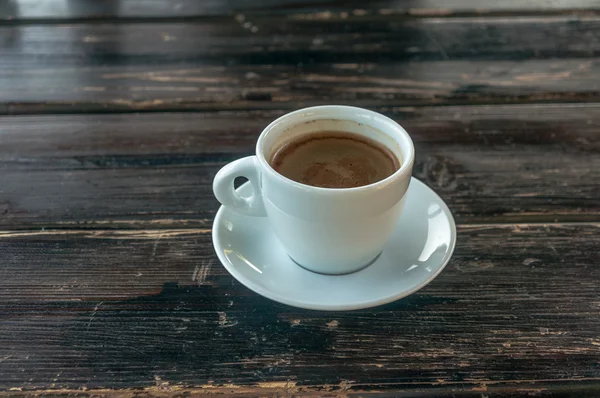 Cup of coffee on a wooden table — Stock Photo, Image