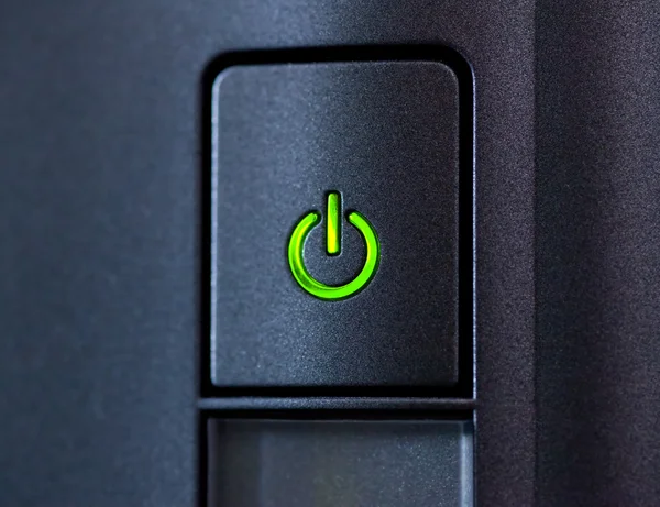 Zeleně svítící tlačítko napájení. Closeup — Stock fotografie