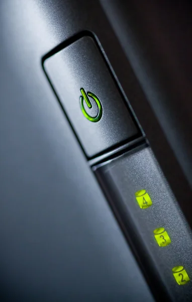 Zeleně svítící tlačítko napájení. Closeup — Stock fotografie