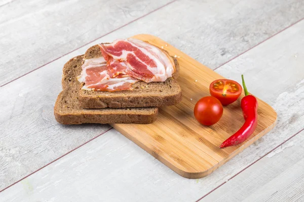 Pomidor, grzanki, mięso i sałatka na drewnianym stole — Zdjęcie stockowe