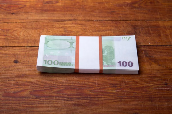 Primer plano de los billetes de 100 euros sobre fondo de madera — Foto de Stock