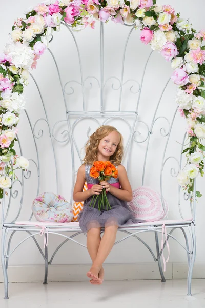 Çok genç kız çiçeklerle oturan — Stok fotoğraf
