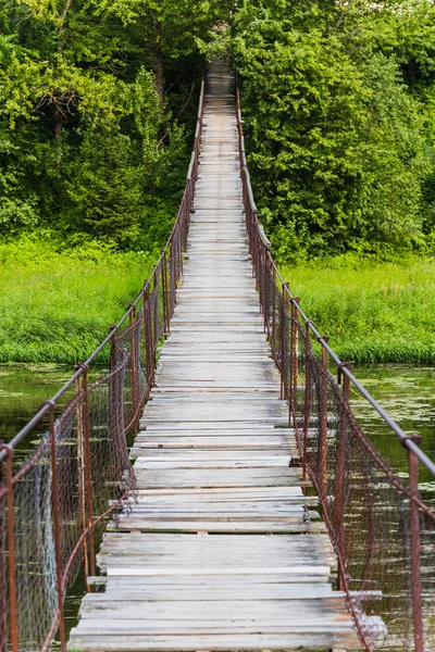 Hanging bridge. Bridge goes over river — Stock Photo, Image
