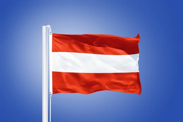 Vlajka Rakouska létal proti modré obloze — Stock fotografie