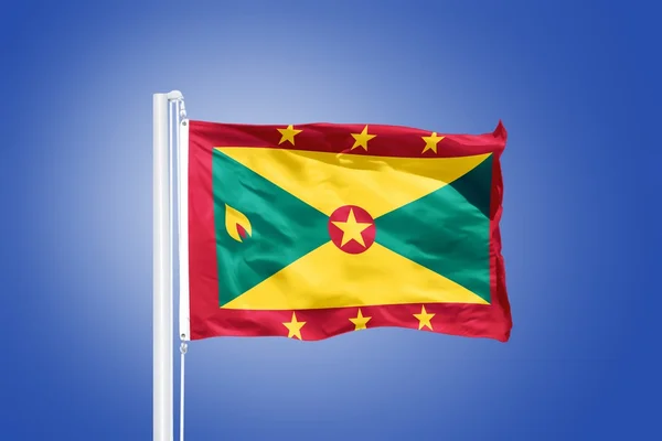 Vlag van Grenada vliegen tegen een blauwe hemel — Stockfoto