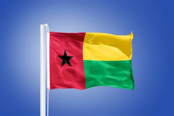 Vlag van Guinee-Bissau vliegen tegen een blauwe hemel — Stockfoto