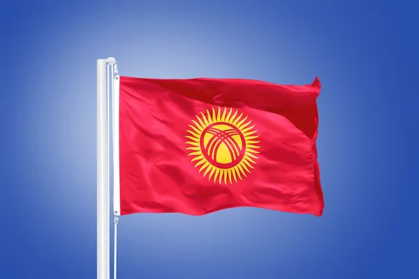 Flag of Kyrgyzstan flying against a blue sky — Stock Photo, Image