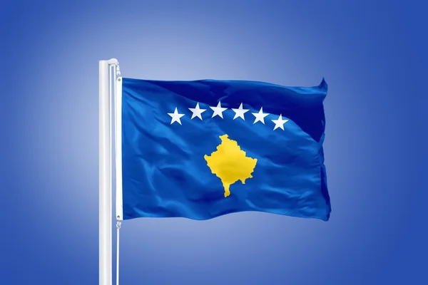 Vlajka Kosova letí proti modré obloze — Stock fotografie