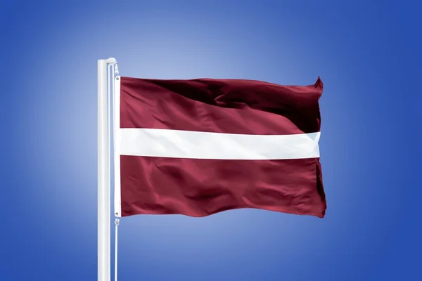 Flag of Latvia flying against a blue sky — Stock Photo, Image