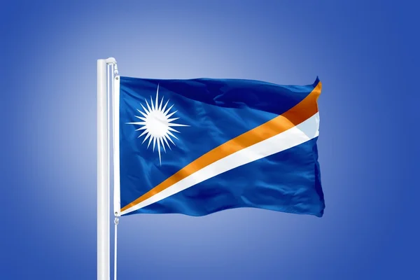 Vlajka Marshallových ostrovů létal proti modré obloze — Stock fotografie