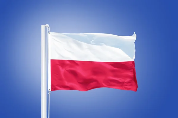 Flaga Polska latający przeciw błękitne niebo — Zdjęcie stockowe
