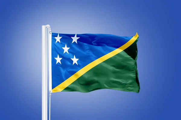 Flag of Solomon Islands flying against a blue sky — Stock Photo, Image