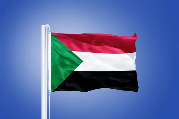 Flag of Sudan flying against a blue sky — Stock Photo, Image