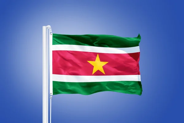 Bandera de Surinam ondeando sobre un cielo azul — Foto de Stock