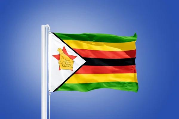 Flagga Zimbabwe flyger mot en blå himmel — Stockfoto