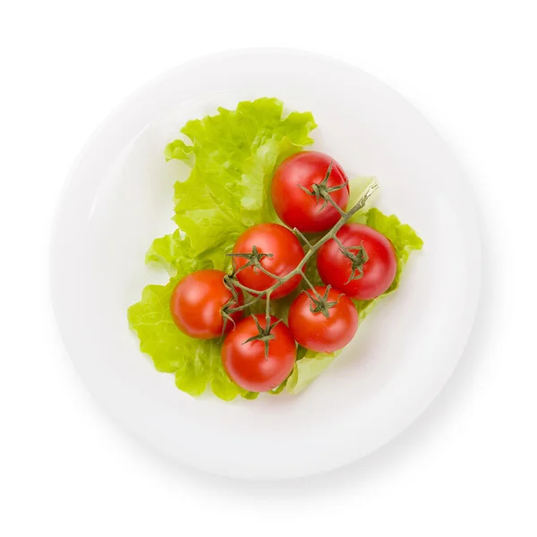 Tomates com folha verde no prato isolado — Fotografia de Stock