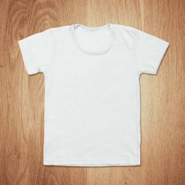 Белая пустая футболка на столе из темного дерева — стоковое фото