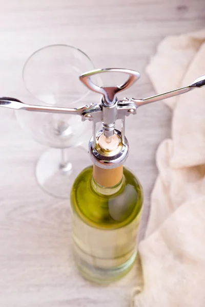 Láhev vína s vývrtkou na dřevěné pozadí — Stock fotografie