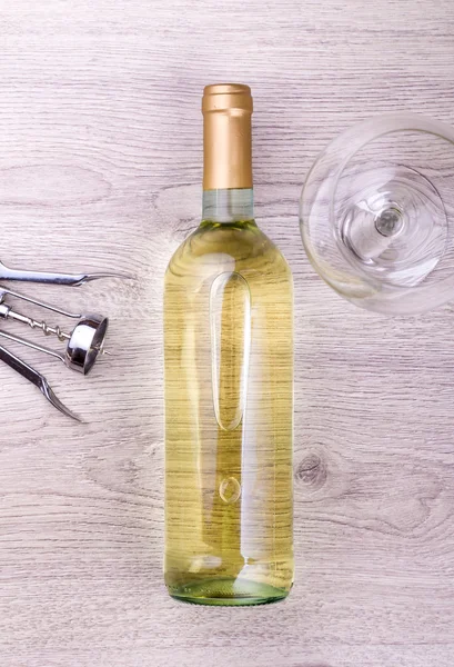 Garrafa de vinho com saca-rolhas em fundo de madeira — Fotografia de Stock