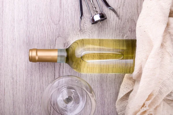 Garrafa de vinho com saca-rolhas em fundo de madeira — Fotografia de Stock