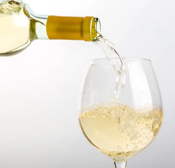 Vin blanc versé dans le verre d'une bouteille — Photo