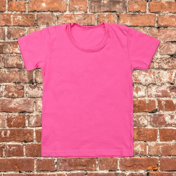 Roze lege t-shirt op donkere bakstenen achtergrond — Stockfoto