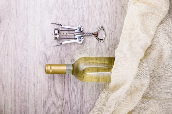 Fles wijn met corkscrew op houten achtergrond — Stockfoto