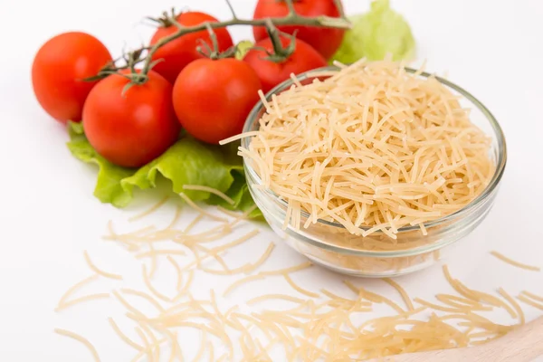 Tomates, folhas e pastas isoladas sobre um branco — Fotografia de Stock