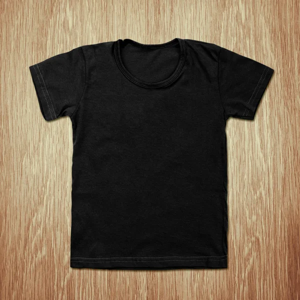 Black blank t-shirt on wooden background — Stock Photo, Image