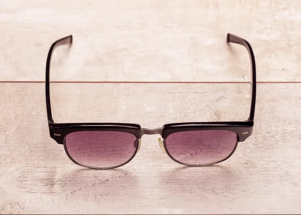 Чорні сонцезахисні окуляри на підлозі деревини — стокове фото