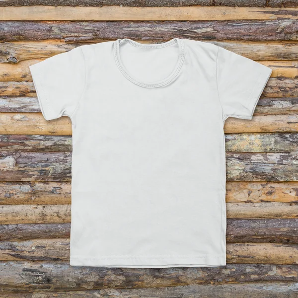 White blank t-shirt on dark wood desk — Stock Photo, Image