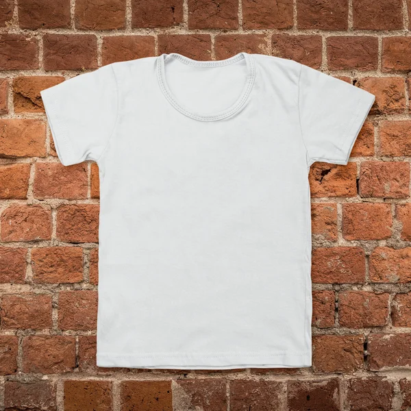 Gray blank t-shirt on dark brick background — Stock Photo, Image