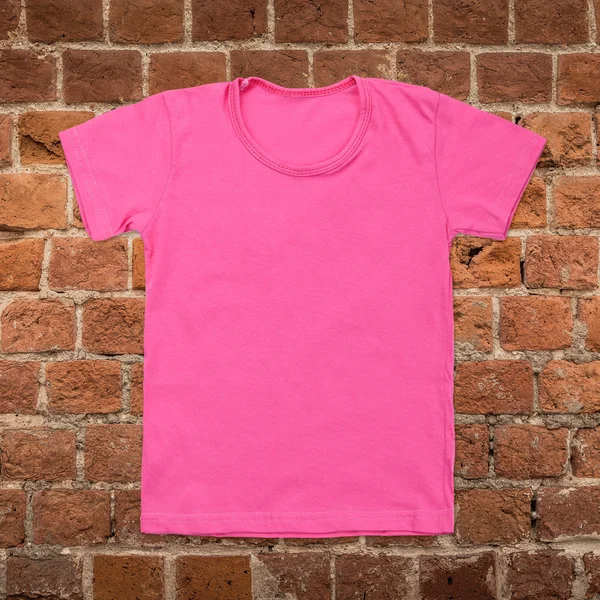 Roze lege t-shirt op donkere bakstenen achtergrond — Stockfoto